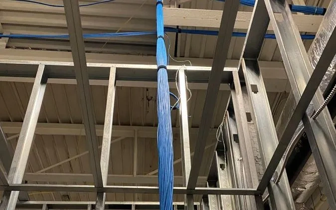 Structured cabling with blue Ethernet cables installed in metal framing for a commercial building.