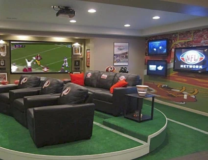 A sports-themed man cave with plenty of entertainment and comfortable seating.