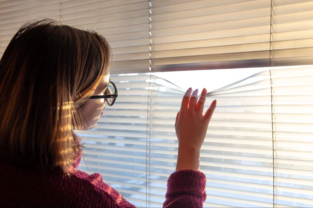 Smart blinds being adjusted manually to control sunlight exposure.