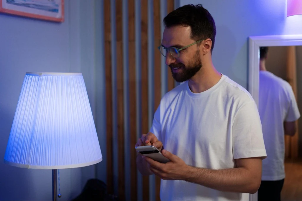 Smart lighting system controlled by a smartphone in a modern living room.